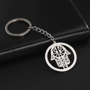 Detail of silver stainless steel Hamsa Hand keychain with intricate scrollwork patterns