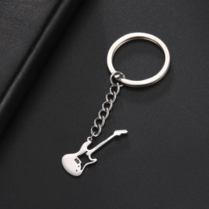 Detailed top view of a polished stainless steel electric guitar keychain on black texture