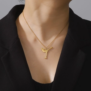 Elegant gold stainless steel necklace featuring a silhouette figure of a figure skater pendant