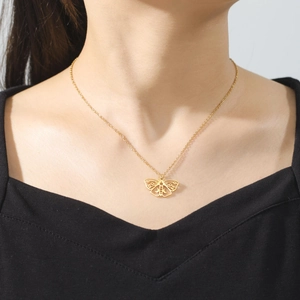 Bohemian gold stainless steel moth pendant necklace with crescent moon cutout on a model