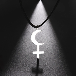 Macro view of polished stainless steel crescent moon and inverted cross pendant on cord