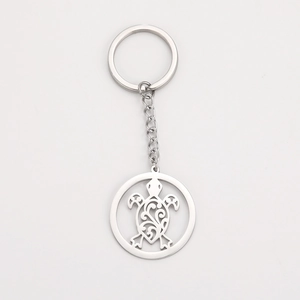 Macro shot of silver turtle pendant keychain showing hollowed-out floral pattern details