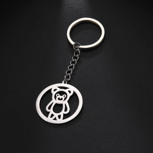 Dettaglio macro di un portachiavi in acciaio inox argento con ciondolo a forma di orso