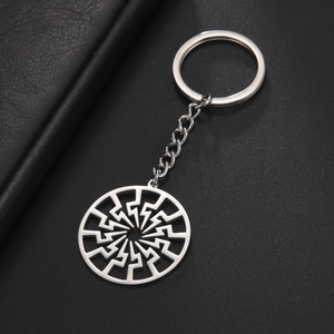 Detailed close-up of hollowed stainless steel lightning pendant keychain on black surface