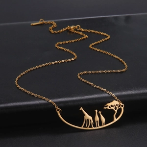 Detailed close-up of a gold giraffe family silhouette pendant with a matching chain