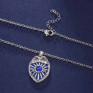 Dettaglio del ciondolo a scudo della polizia in argento con pietra blu e chiusura
