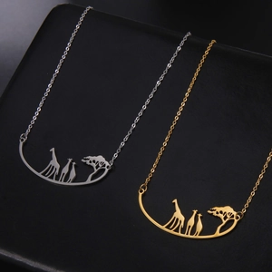 Macro detail of giraffes and tree silhouettes on gold and silver stainless steel pendants
