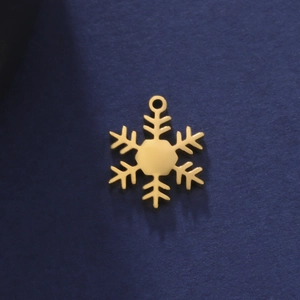 Détail macro d'un pendentif flocon de neige doré évidé avec finition polie pour bijoux DIY