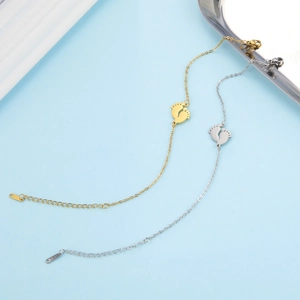 Détail de pendentifs empreintes de bébé sur des bracelets en acier inoxydable doré et argenté