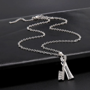 Collar creativo plateado con colgante de cepillo y pasta de dientes con cristales brillantes