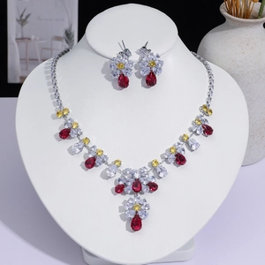 Vue détaillée d'un ensemble collier et boucles d'oreilles aux cristaux gouttes rouges.