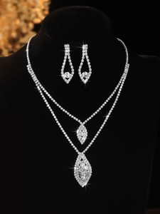 Macro shot of silver bridal jewelry set with sparkling rhinestones on black velvet