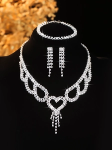 Close-up of silver bridal jewelry set with sparkling rhinestones and heart tassel detail