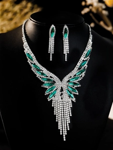 Close-up of bridal jewelry set with green marquise stones and silver tassel fringe