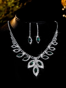 Close-up of sparkling bridal jewelry set with emerald gemstones and multi-row crystals