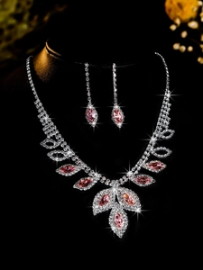 Macro shot of bridal jewelry set with pink marquise stones and zircons on black stand