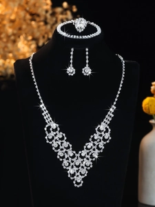 Detailed view of luxury silver bridal jewelry set with sparkling rhinestones on black bust