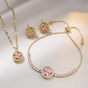 Macro-detail van gouden bloemen sieradenset met roze stenen en armband