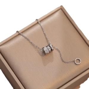 Silver Roman cylinder pendant necklace with tassels and small crystals on a jewelry box