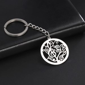 Macro view of stainless steel keychain with treble clef and filigree scrollwork pendant