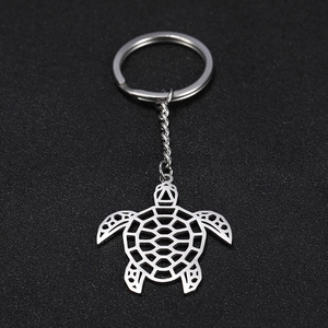 Gros plan d'un porte-clés tortue en acier inoxydable argenté avec découpes ajourées