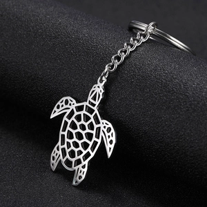 Détail macro d'un porte-clés tortue marine en acier inoxydable avec design en métal évidé