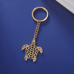 Porte-clés tortue en acier inoxydable doré poli sur fond bleu foncé élégant