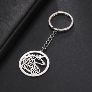 Détail du porte-clés en acier inoxydable avec pendentif licorne évidé sur fond noir