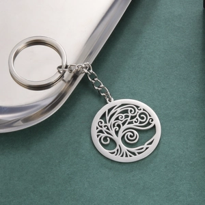 Porte-clés Arbre de Vie en acier inoxydable avec pendentif découpé sur fond texturé vert