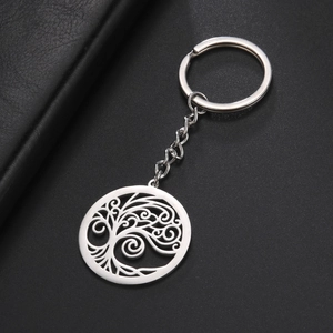 Vue détaillée d'un pendentif arbre de vie en acier sur une surface en cuir noir texture