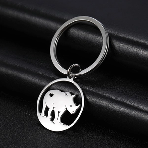 Close-up of a stainless steel rhino keychain with heart detail on a black leather background