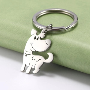 Detail eines Schlüsselanhängers aus Edelstahl in Hundeform auf hellgrünem Leder