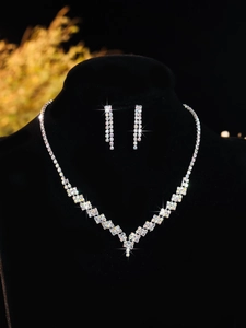 Detail of shimmering zircon bridal jewelry set featuring a V-shaped necklace and drop earrings