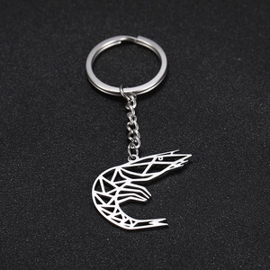 Detailed macro view of the minimalist hollowed-out shrimp pendant on a silver keychain