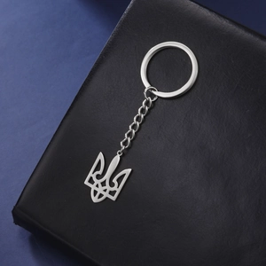 Detailed macro view of the silver stainless steel Ukraine trident keychain on leather