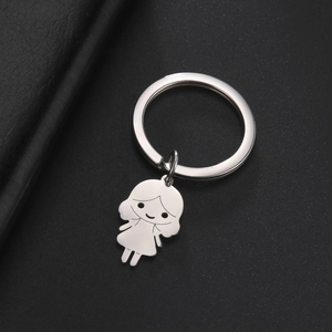 Détail macro d'un porte-clés en acier inoxydable 304 poli avec pendentif fille cartoon
