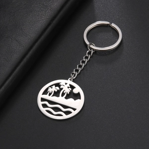Macro view of stainless steel keychain with hollow coconut tree and beach waves design