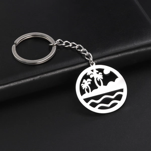 Detail of silver stainless steel keychain with hollow tropical beach palm tree pendant