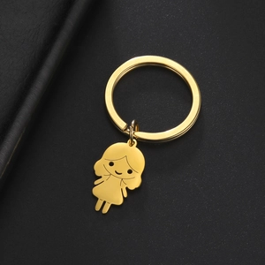 Gros plan détaillé d'un pendentif fille de dessin animé doré sur un porte-clés en acier poli