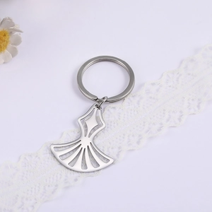 Macro detail of silver stainless steel hollow fan pendant keychain on white lace