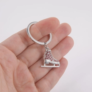 Détails de macro d'un porte-clés patins à glace avec strass roses et métal argenté poli