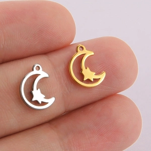 Star and crescent moon pendant in gold and silver finish shown on finger for scale