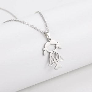 Macro detail of cut-out stainless steel girl pendant on a fine silver-toned chain