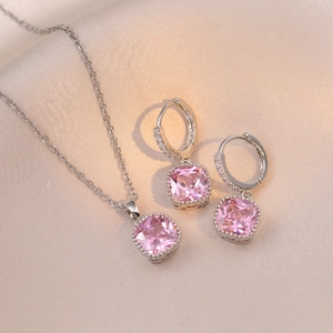 Détail de la parure collier et boucles d'oreilles en argent avec zircon rose sur soie champagne