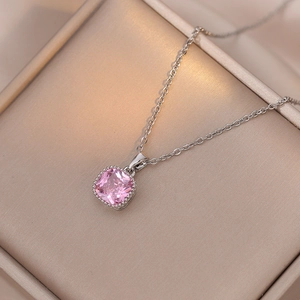 Détail d'un pendentif en zircon rose carré sur une chaîne en argent dans un écrin à bijoux