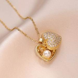 Detailed close-up of a golden heart pendant necklace with micro-paved cubic zirconia and pearl