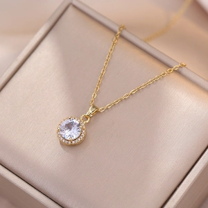 Elegante goldene Titankette mit funkelndem runden Zirkon-Halo-Anhänger auf einer Schmuckschatulle