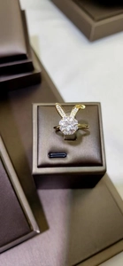 Dettaglio di un anello a forma di coniglio dorato con zirconi su base in pelle