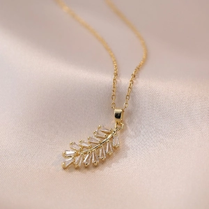 Elegante collana a foglia piuma placcata oro con zirconi baguette su tessuto di seta