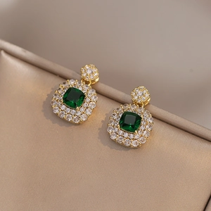 Vintage smaragdgroene oorbellen met dubbele halo diamanten op een gouden afwerking